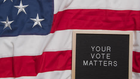 Schild-Mit-Der-Aufschrift-„Ihre-Stimme-Ist-Wichtig“-Liegt-Auf-Der-US-Flagge-„Stars-And-Stripes“-Für-Die-Amerikanische-Wahl-2024